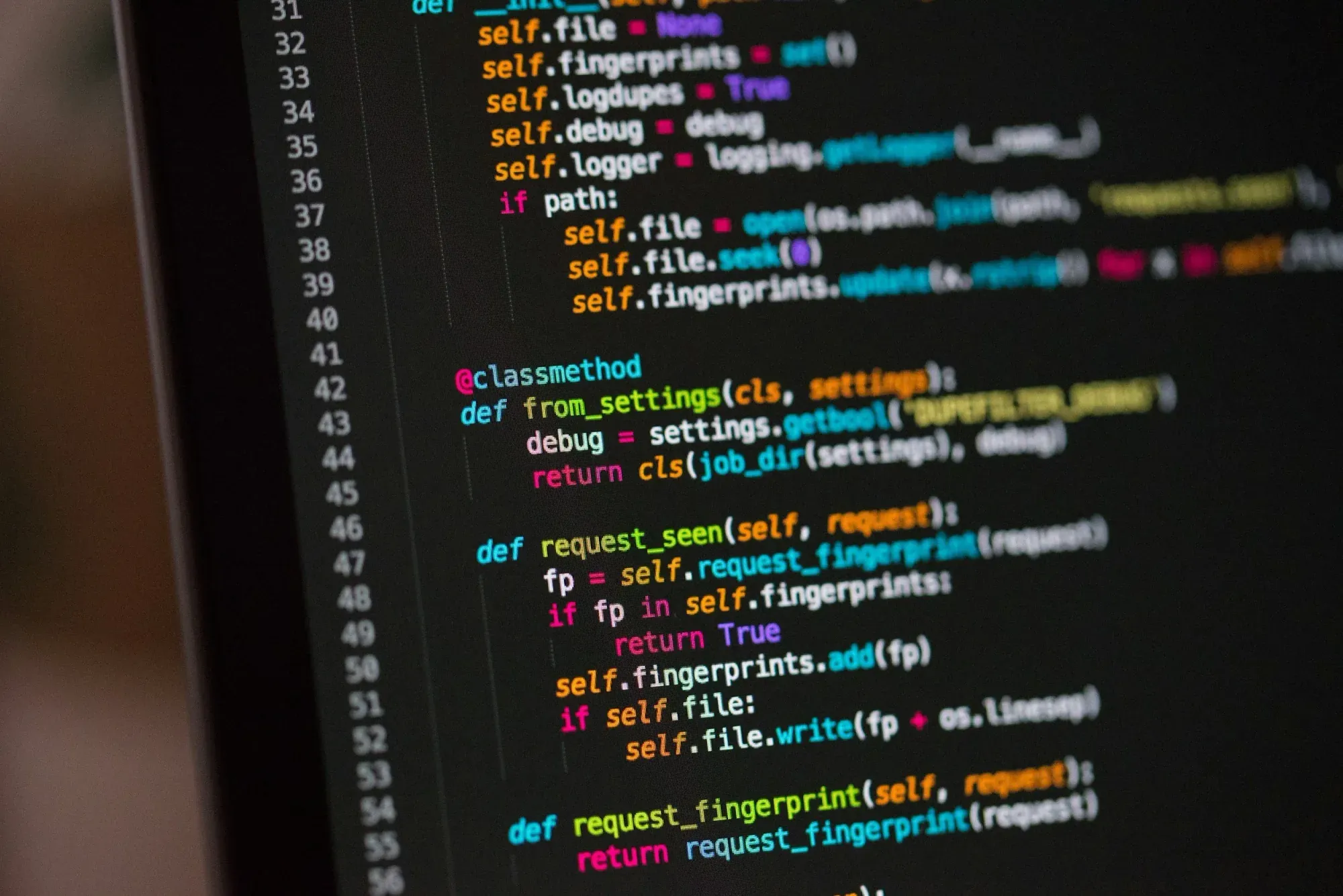 Close-up of a computer screen displaying colorful programming code with syntax highlighting.